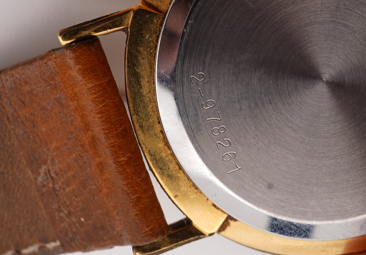 A gentleman's steel and gold plated Bulova Longchamp manual wind wrist watch, with baton numerals, case diameter 33mm, on a tanned leather strap.